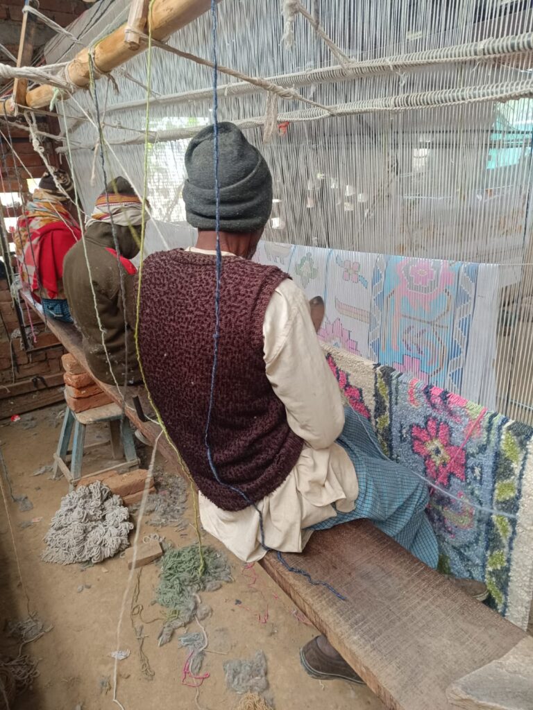 Handmade Indian carpet with geometric tribal pattern in brown and beige